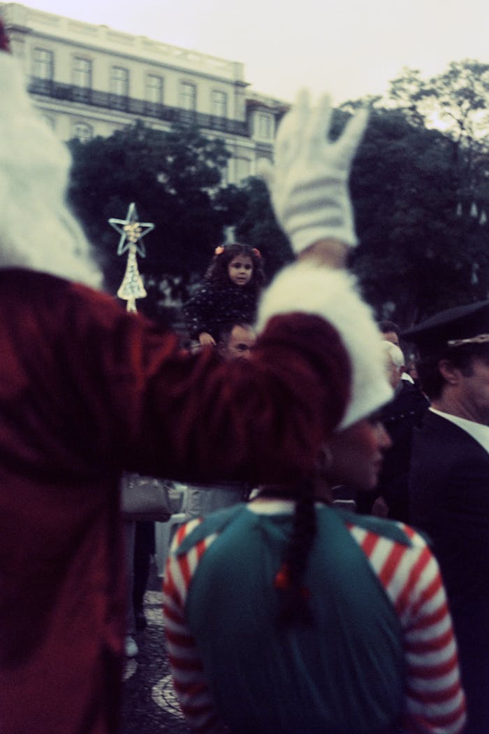 A vibrant festival parade with people in traditional costumes on Lisbon's festive streets.