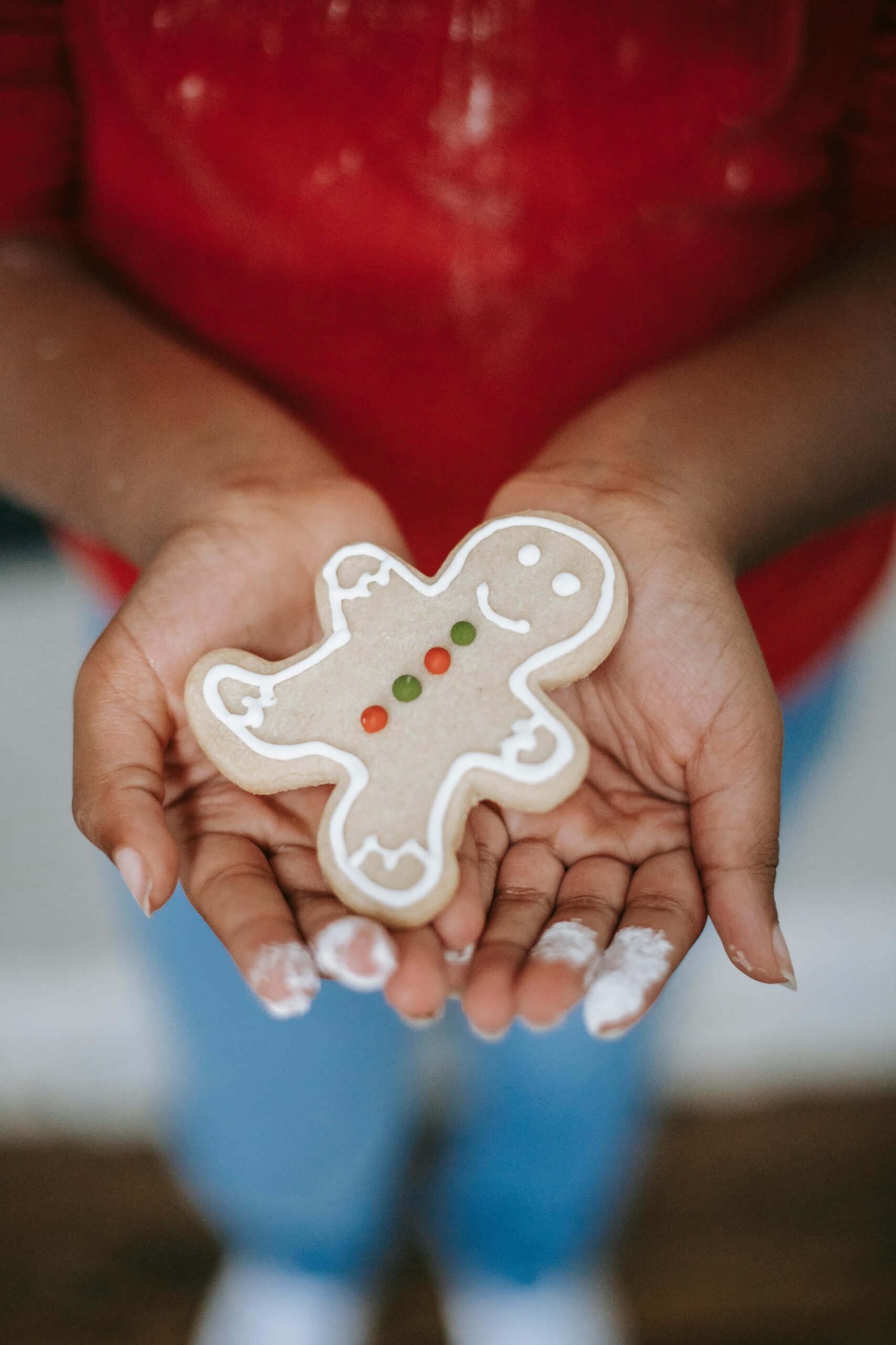 Parade Day Activities Close-up of a child holding a homemade gingerbread cookie in their hands.