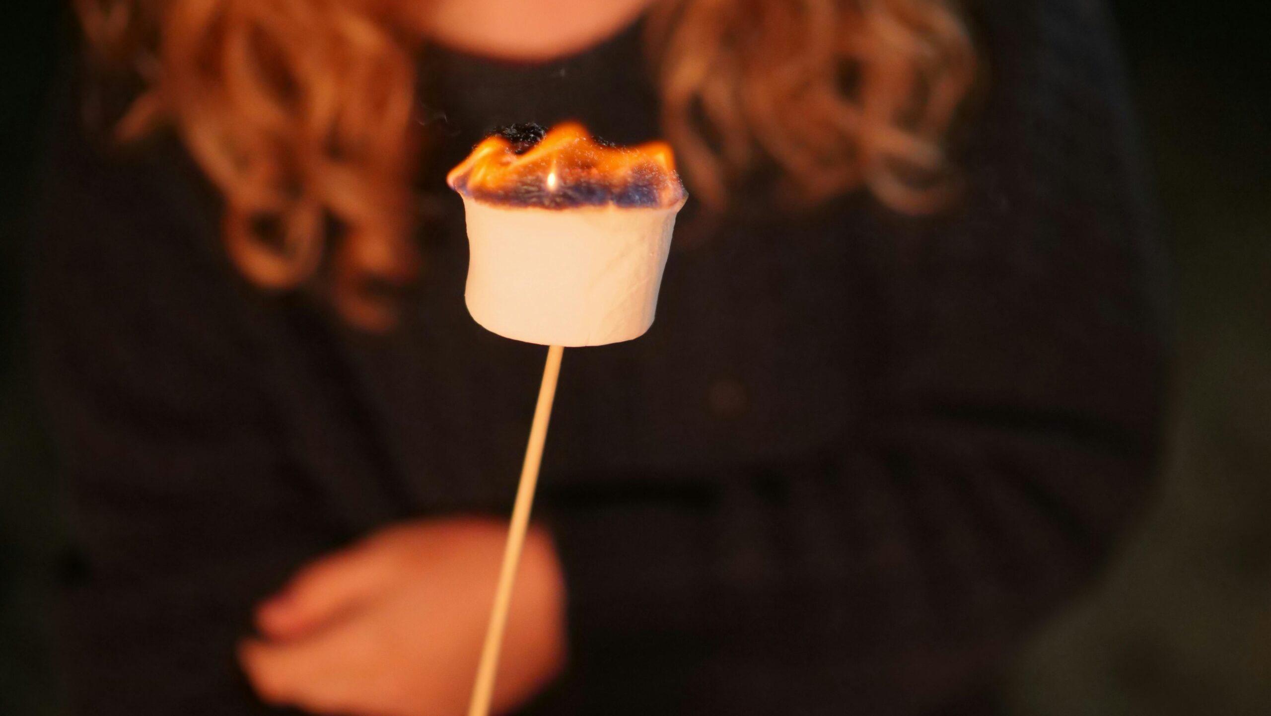 Parade Day Activities Close-up of a marshmallow being roasted over a campfire, perfect for camping-themed content.